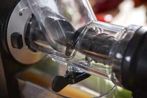 Bei einem Slow Juicer werden die Zutaten mithilfe einer Pressschnecke zerdrückt und durch ein Sieb gepresst.