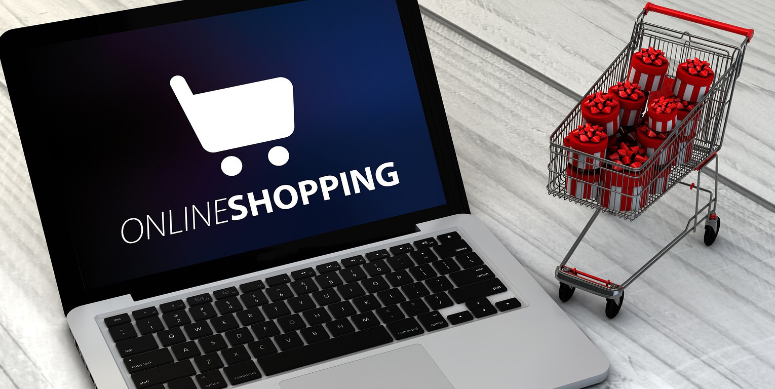 Online-Shopping am Computer mit kleinem Einkaufswagen