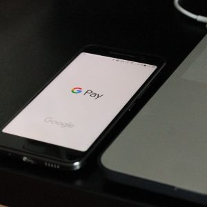 Android-Smartphone mit Google Pay vor schwarzem Hintergrund