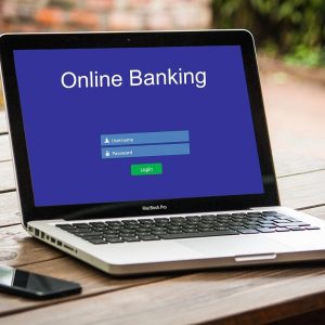 Online-Banking-Anzeige vor blauem Hintergrund auf Notebook
