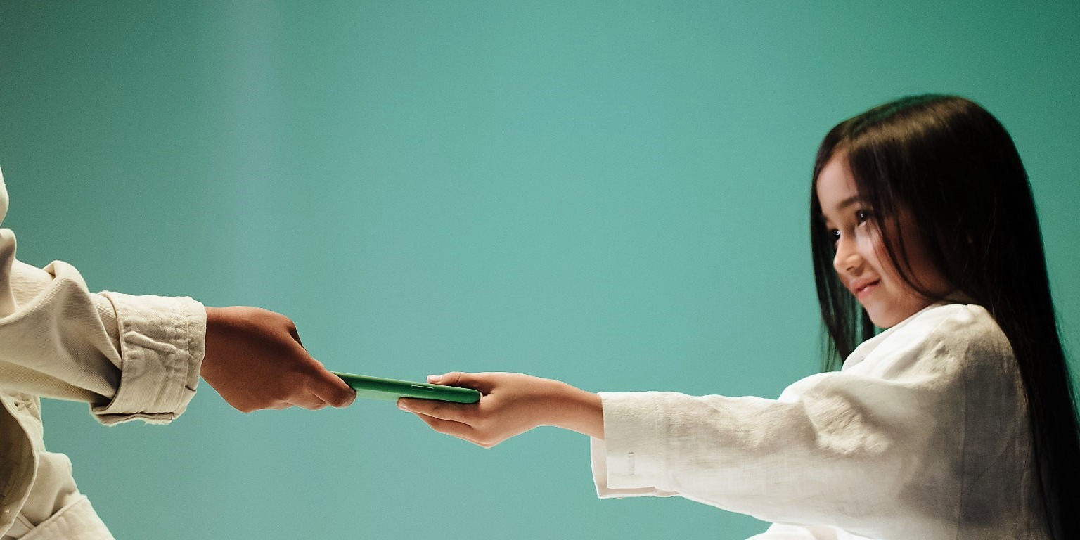 Kind bekommt Smartphone gereicht