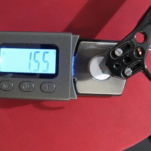 Tonabnehmer auf spezieller Waage mit Gewichtsanzeige vor rotem Hintergrund