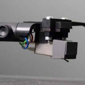 Tonabnehmer und Headshell vor grauem Hintegrund