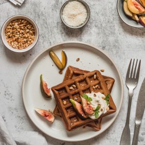 Gesunde Waffeln mit Obst und Nüssen auf Tisch