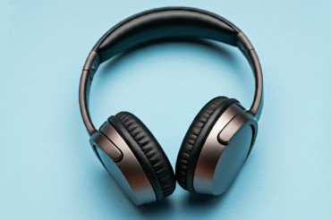 Bluetooth-Kopfhörer: Guter Klang für kleines Geld? Kabelloser Kopfhörer auf hellblauem Untergrund