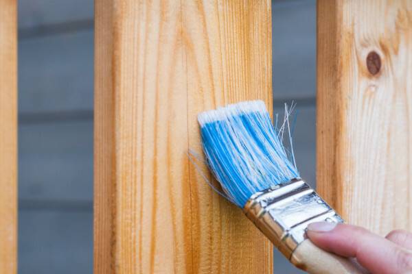 ÖKO-TEST Holzschutzlasuren-Vergleich: „Der Frühling kann kommen“ Pinsel streicht Lasur auf Holz