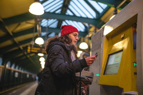 Junge Frau kauft Ticket am Fahrscheinautomaten. Bild: iStock/FluxFactory