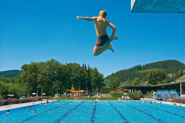 Ranking: 2.000 Freibäder im Vergleich Junge springt in Freibadbecken